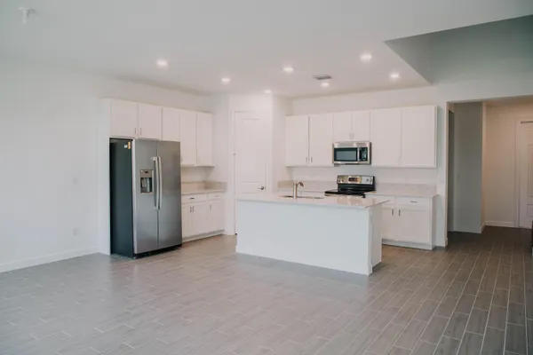 a kitchen with stainless steel appliances white cabinets and wooden floor
