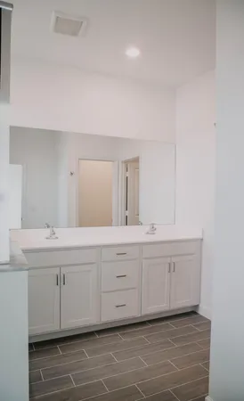 a spacious bathroom with a double vanity sink and a mirror
