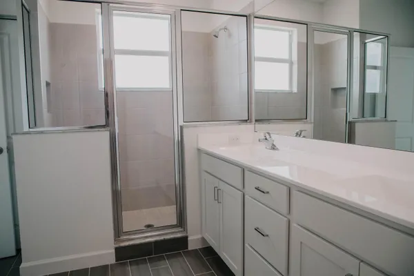 a bathroom with a shower sink and mirror