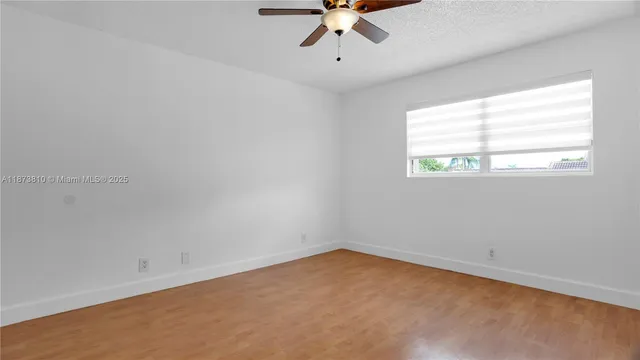 a view of hallway with paintings on wall and a shower