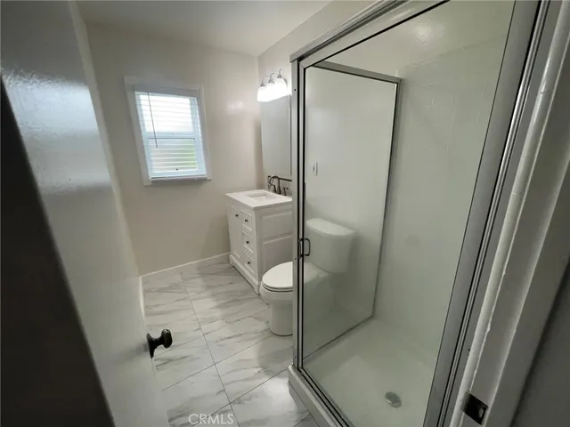 a bathroom with a granite countertop sink a toilet and a mirror