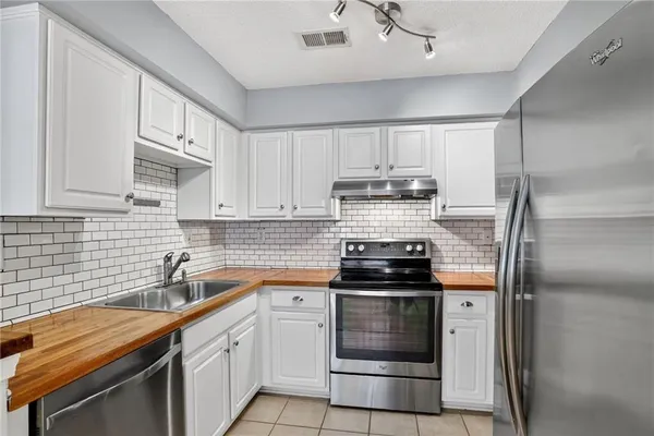 a kitchen with a sink appliances and cabinets