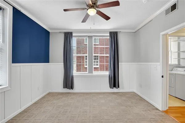 an empty room with windows and fan