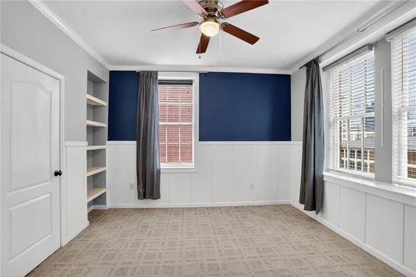 an empty room with windows and cabinet