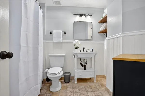 a bathroom with a sink toilet and mirror