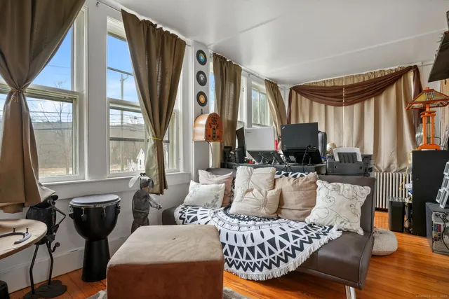 a living room with furniture a fireplace and a large window