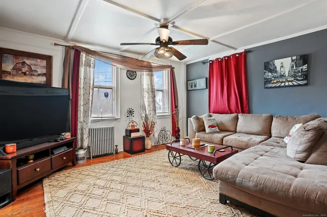 a living room with furniture a flat screen tv and a chandelier