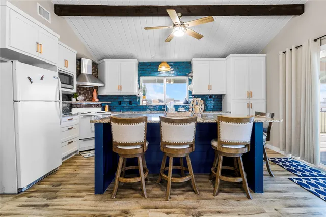 a kitchen with a stove a table and chairs in it