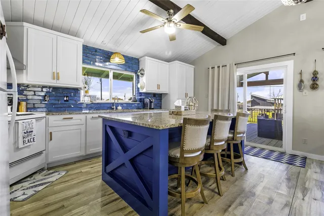 a large kitchen with stainless steel appliances granite countertop sink stove and refrigerator