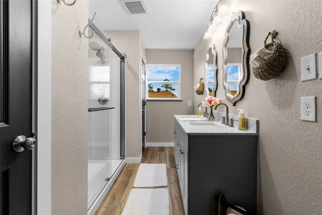 a bathroom with a granite countertop sink mirror bathtub and shower