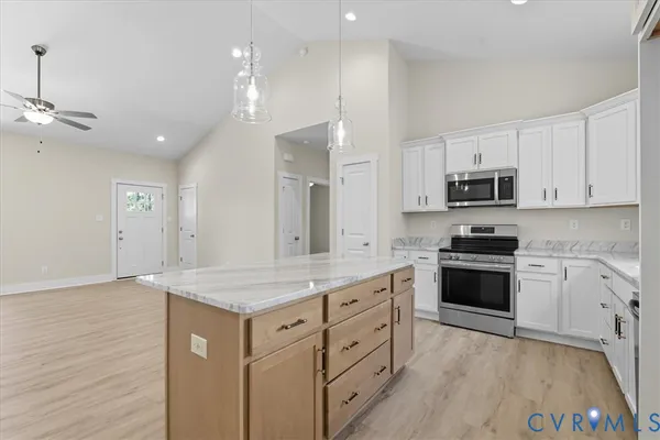 a kitchen with stainless steel appliances granite countertop a stove a sink and a microwave