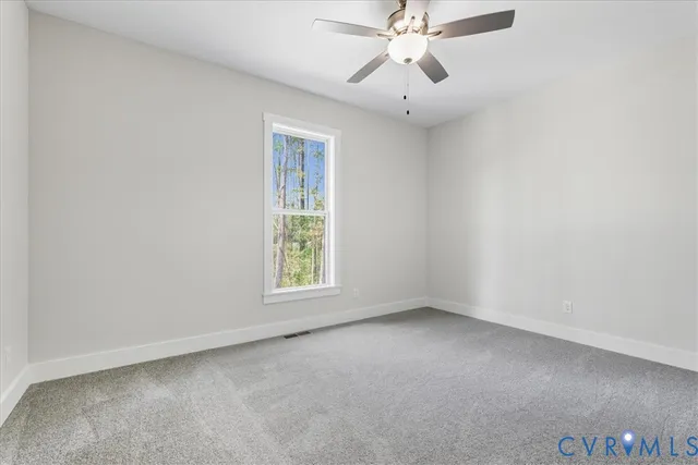 an empty room with a ceiling fan and a window