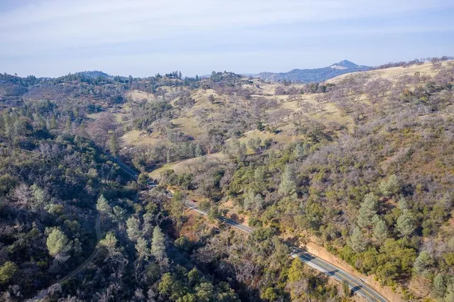 a view of a dry yard with mountains in the background