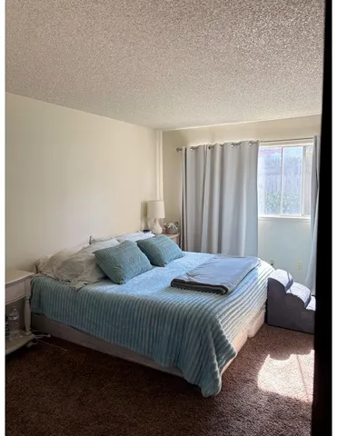 a bedroom with a bed and a window