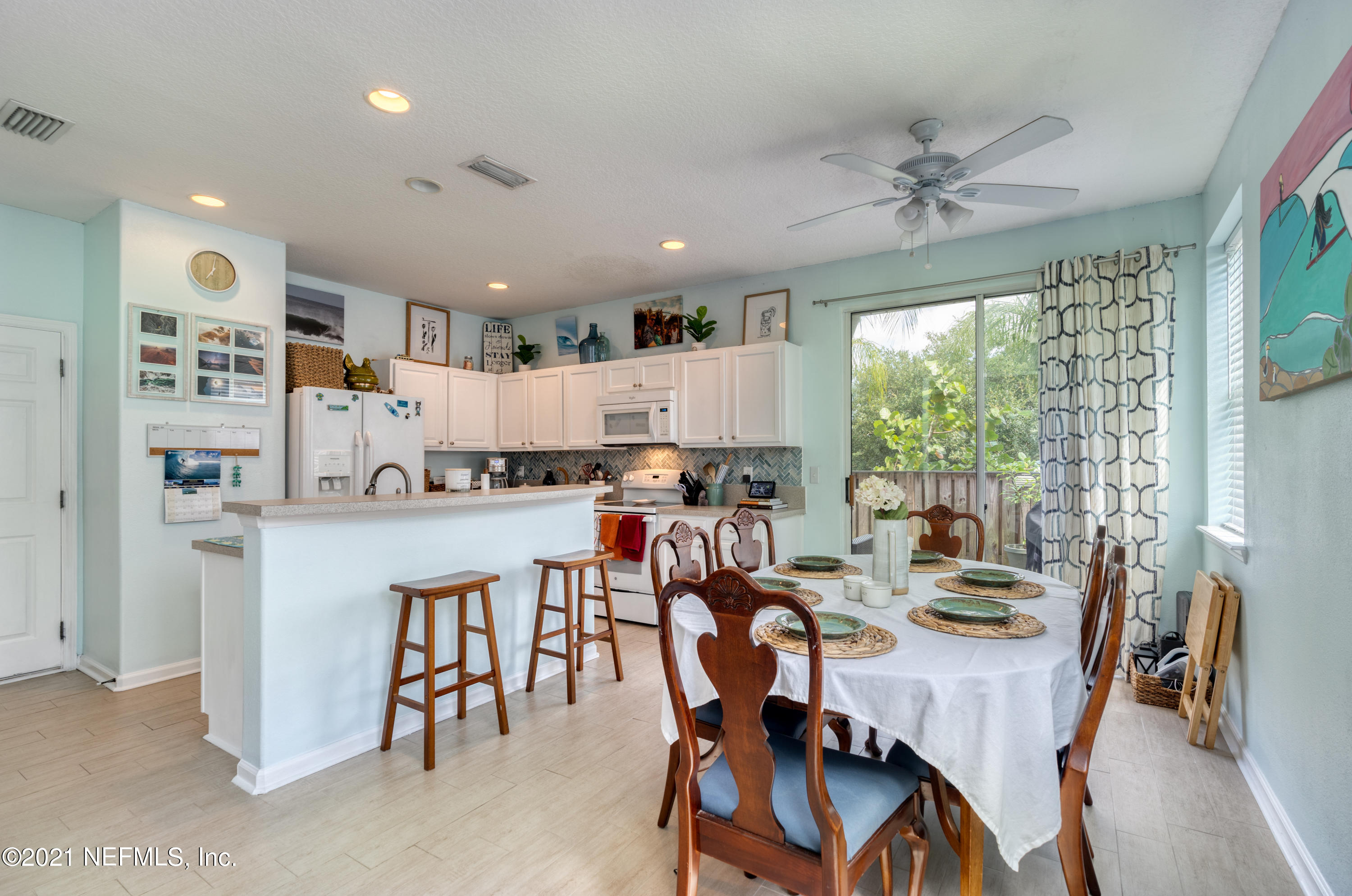 167 Bay Bridge Drive St. Augustine, FL 32080 - Photo 19 of 32 a dining room with kitchen island furniture a large window and stainless steel appliances