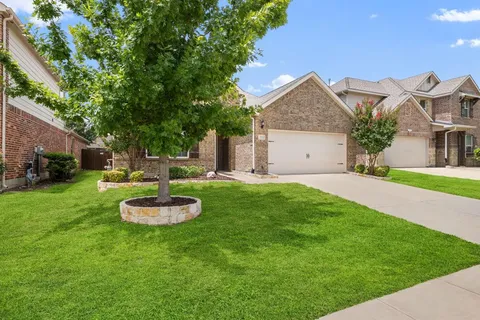 a big house with a big yard and potted plants