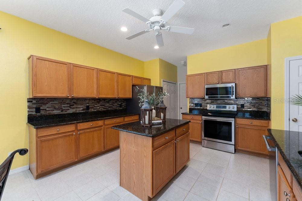 3463 Creek Run Lane Eustis, FL 32736 - Photo 26 of 83 a kitchen with stainless steel appliances granite countertop a stove and a sink
