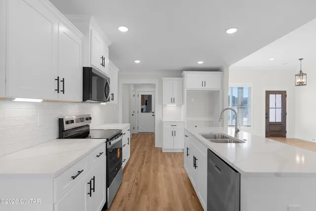 a large kitchen with stainless steel appliances lots of counter space and wooden floor