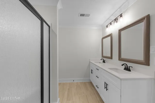 a bathroom with a double vanity sink and mirror