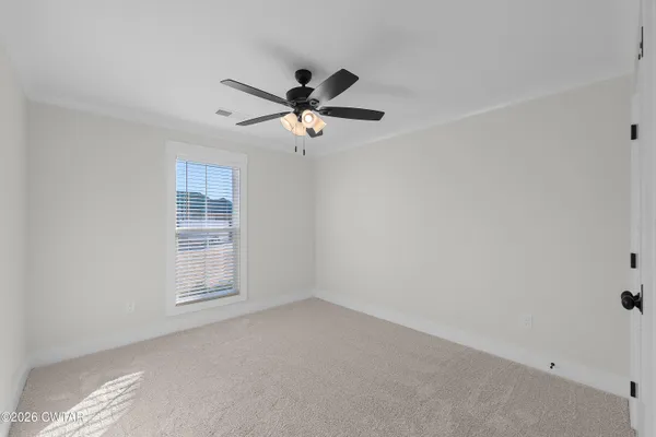 an empty room with windows and fan