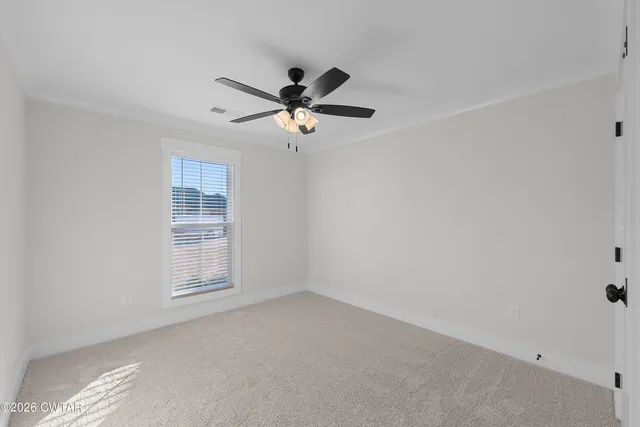 an empty room with windows and fan