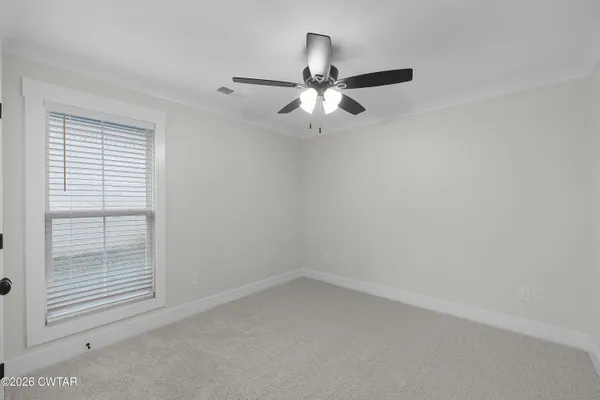 an empty room with a window and a fan
