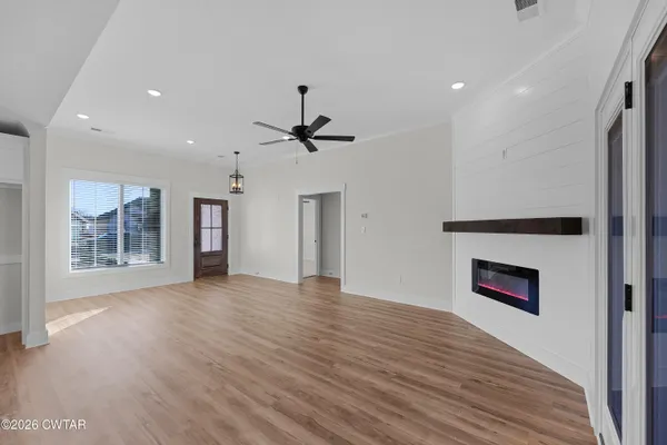 a view of an empty room with a window and fireplace