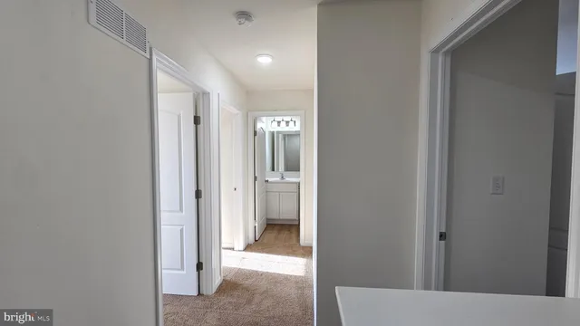 a view of a hallway with closet and a bathroom