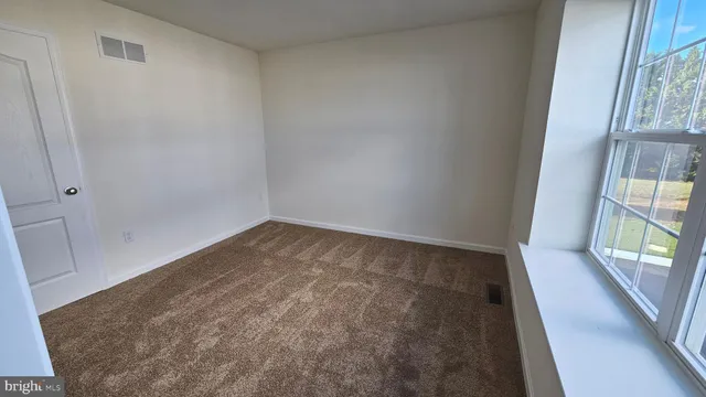 a view of room with window and wooden floor
