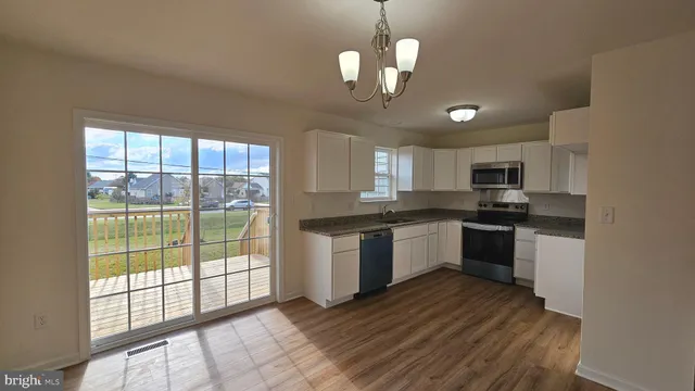 a large kitchen with a large window and stainless steel appliances