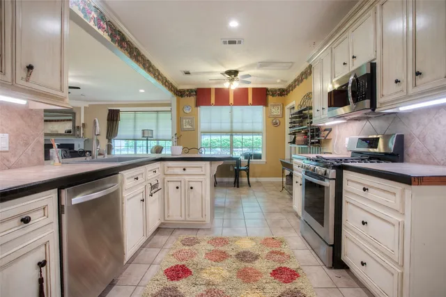 a kitchen with stainless steel appliances kitchen island granite countertop a sink and cabinets
