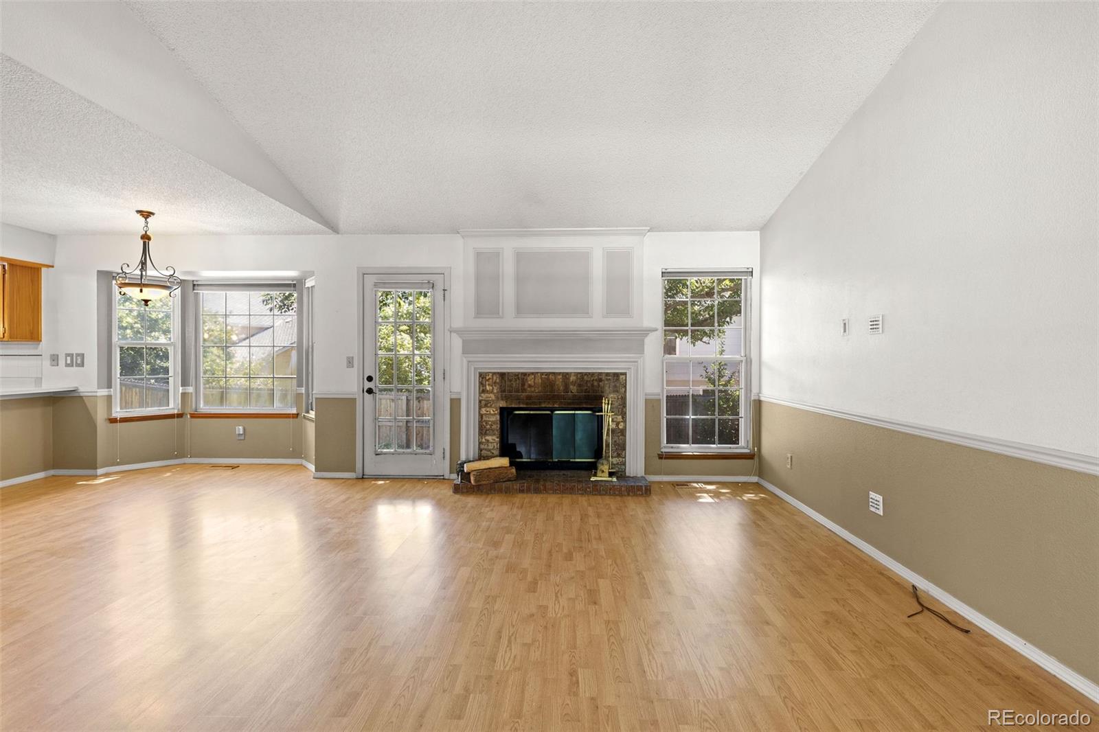 8536 Union Circle Arvada, CO 80005 - Photo 6 of 26 an empty room with wooden floor fireplace and windows