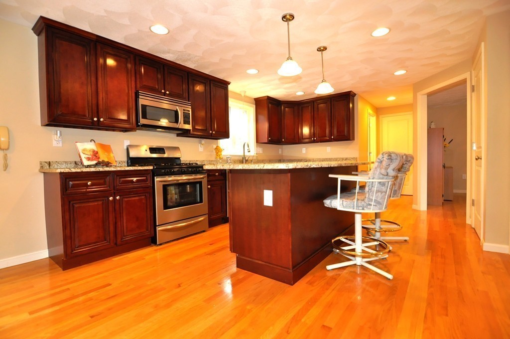 6 Dell Hollow Road Billerica, MA 01821 - Photo 6 of 25 a kitchen with stainless steel appliances granite countertop a stove a sink dishwasher and a microwave oven with cabinets