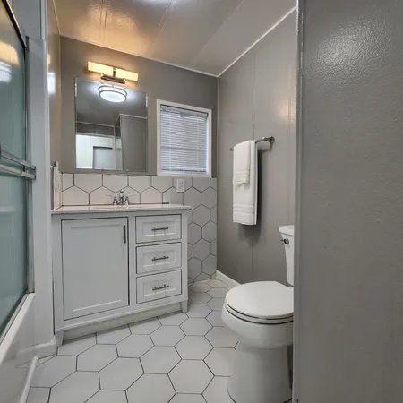 a kitchen with a refrigerator and white cabinets