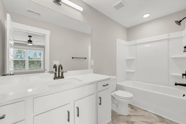 a bathroom with a sink toilet vanity and tub
