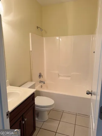 a bathroom with a granite countertop sink a toilet and shower