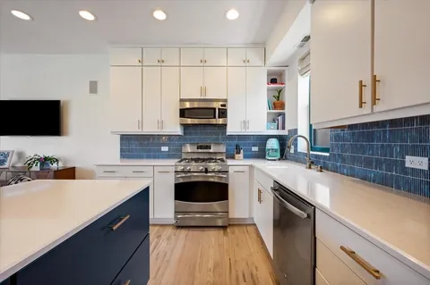 a large kitchen with stainless steel appliances granite countertop a stove a sink a table and chairs