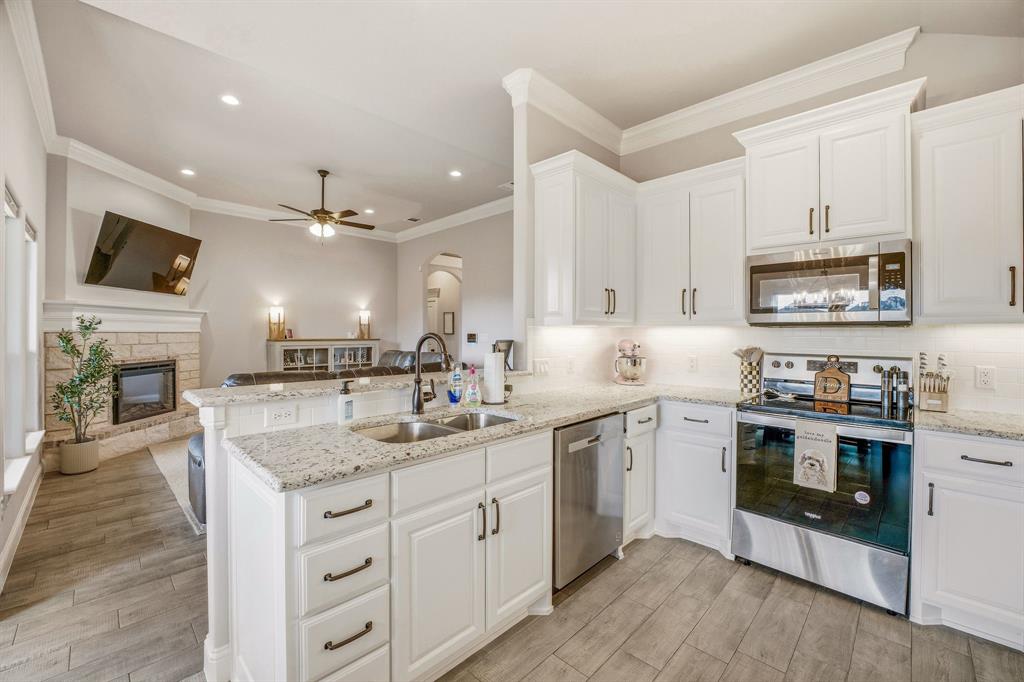 601 Violet Tolar, TX 76476 - Photo 7 of 26 a kitchen with a sink stove cabinets and wooden floor