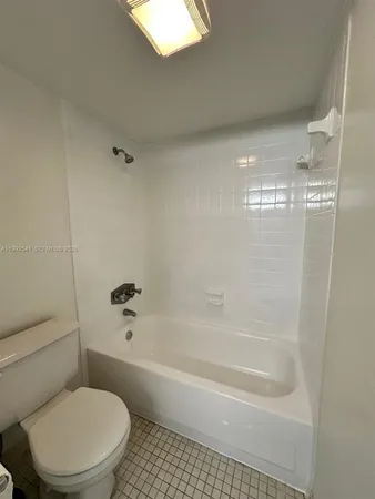 a white toilet sitting next to a bath tub