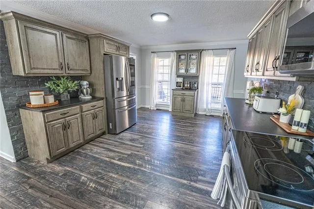 a kitchen with stainless steel appliances granite countertop a refrigerator and a stove