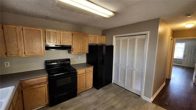 a kitchen with granite countertop wooden cabinets and stainless steel appliances
