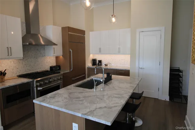 a kitchen with granite countertop a stove a sink and a refrigerator
