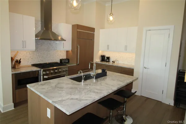 a kitchen with stainless steel appliances granite countertop a sink a stove and a refrigerator