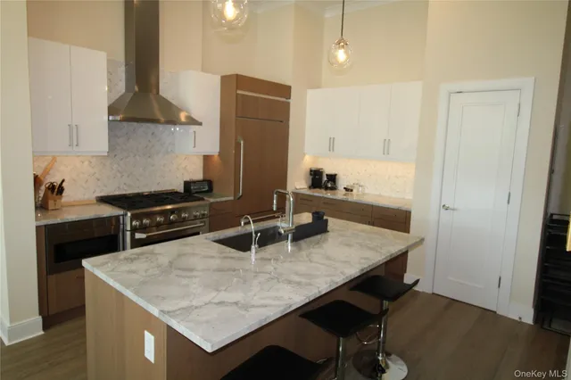a kitchen with stainless steel appliances granite countertop a sink a stove and a refrigerator