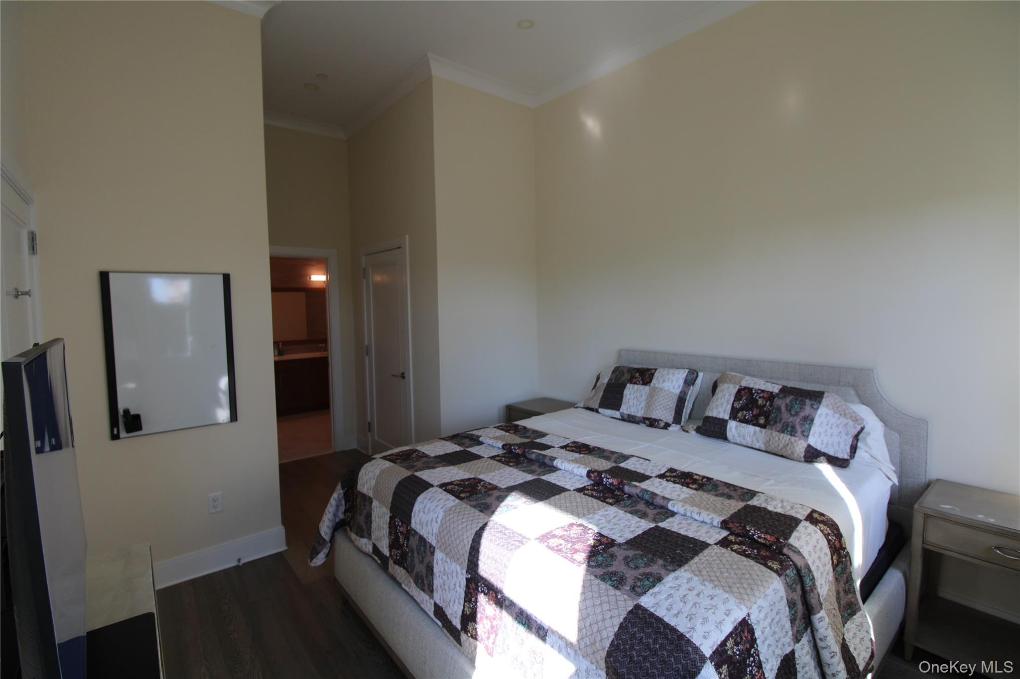 100 Garvies Point Road, Unit 1039 Glen Cove, NY 11542 - Photo 9 of 12 a bedroom with a bed and a mirror