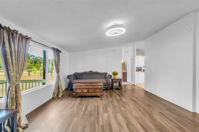 a living room with furniture and a wooden floor