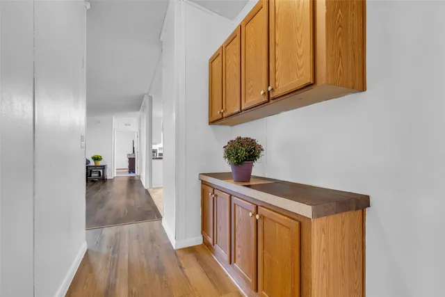 a view of a hallway with wooden floor and staircase