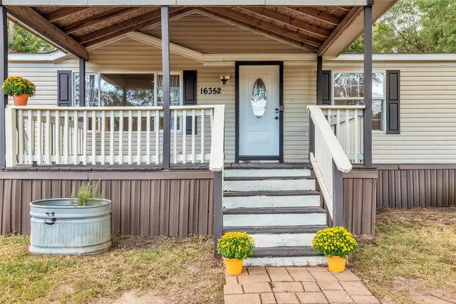 a view of a porch with furniture and wooden floor