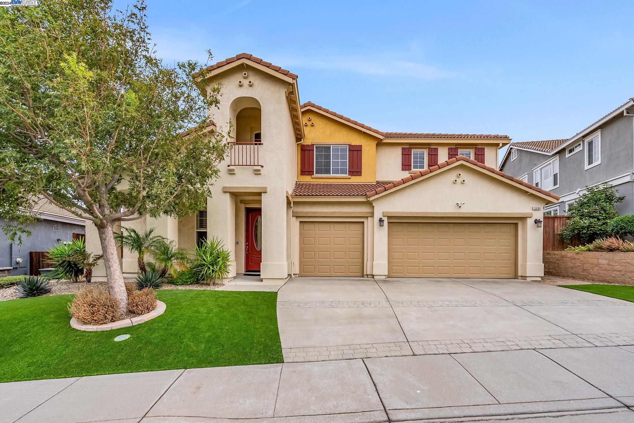 a front view of a house with yard and green space