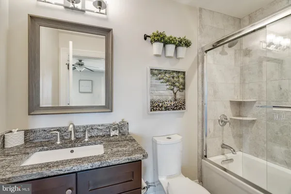 a bathroom with a granite countertop sink toilet and shower